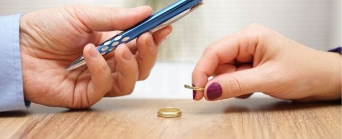 spouse handing pen for divorce signature